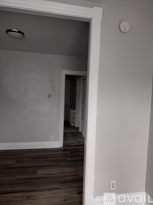 A room with a wooden floor and a white door.
