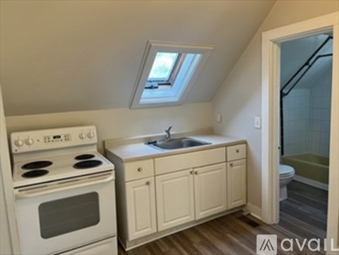 A kitchen with a white stove and cabinets.