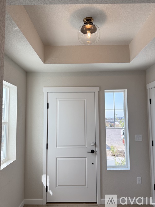 A white two-story house with a garage door open.