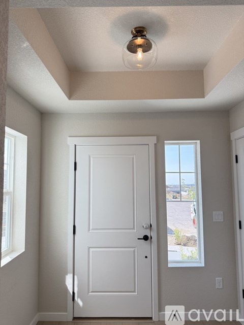 A white two-story house with a garage door open.