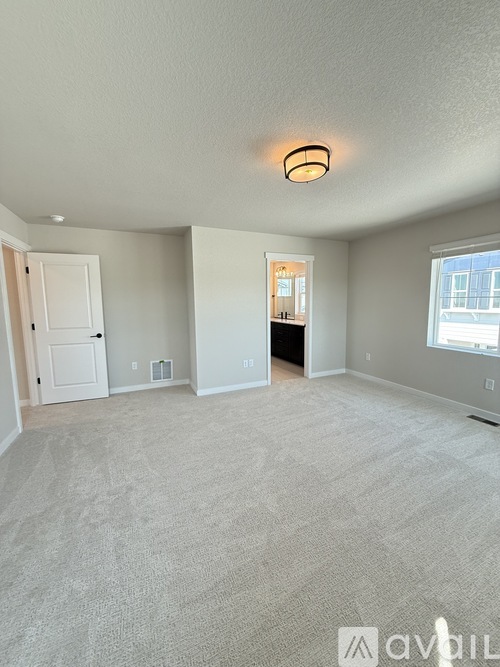 A spacious room with a carpeted floor and a ceiling light.