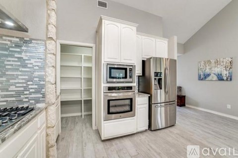 A kitchen with a stove top oven and a refrigerator.