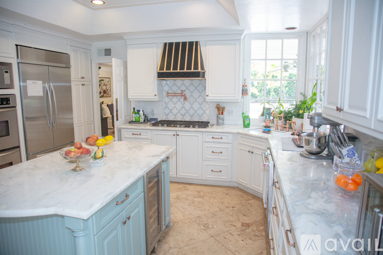 A kitchen with a marble countertop and white cabinets.