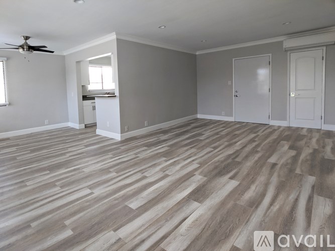 A room with wooden flooring and a ceiling fan.
