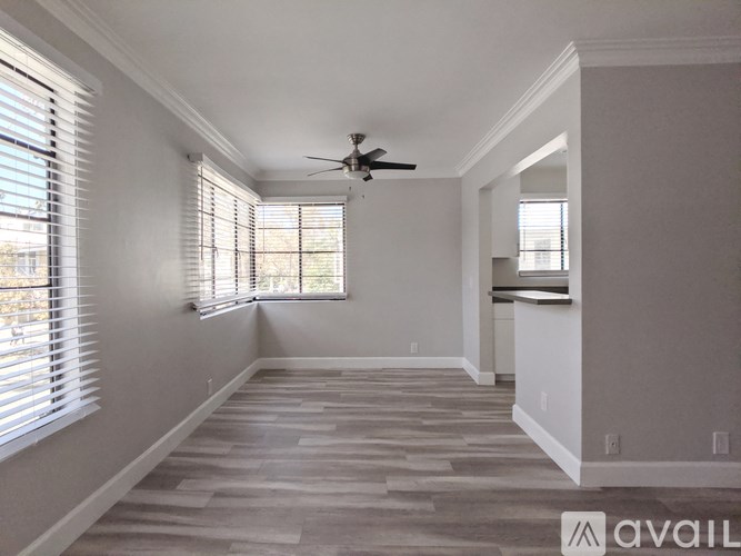 A spacious room with a fan and a window with blinds.