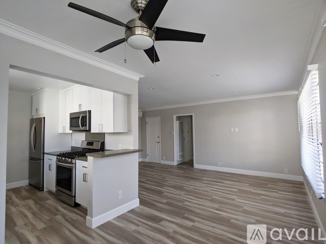 A kitchen with a white counter and a fan on the ceiling.