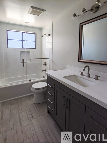 A bathroom with a toilet, sink, and mirror.