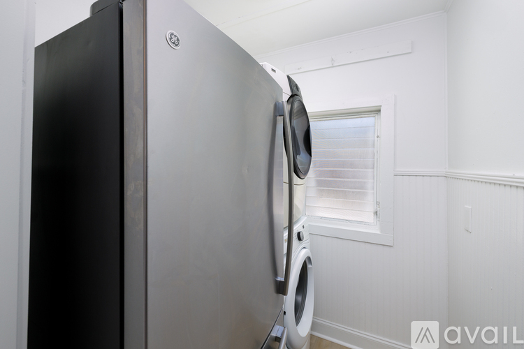 A black and silver fridge in a white room.