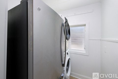 A black and silver fridge in a white room.