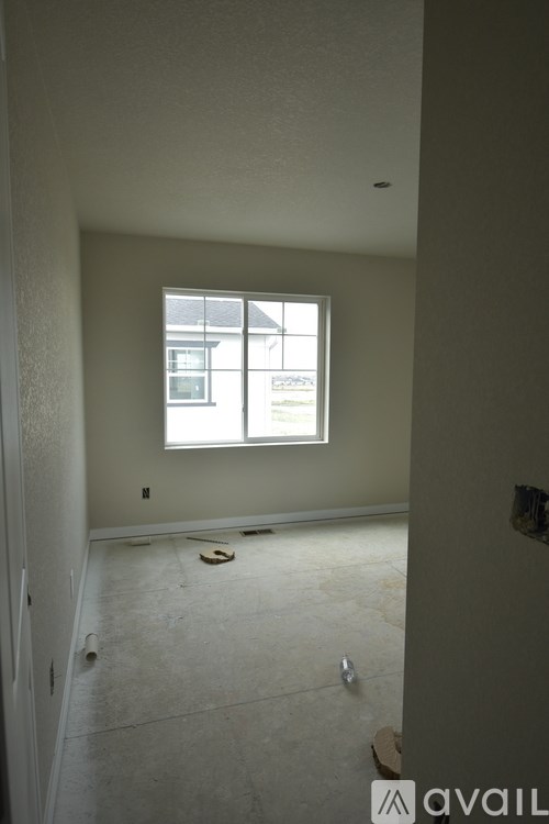 A room with a window and a door is available for rent.