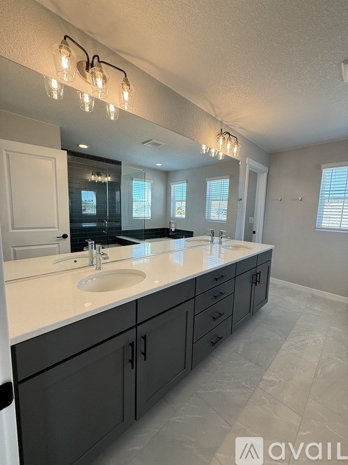 A bathroom with a vanity, sink, and mirror.