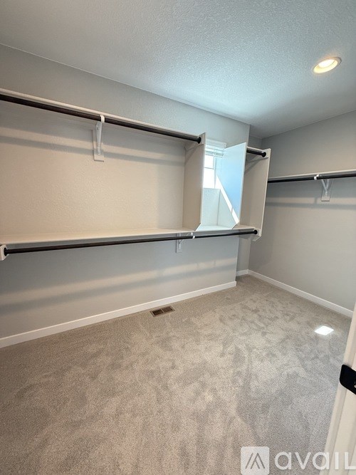A room with a carpeted floor and a wall-mounted shelf.