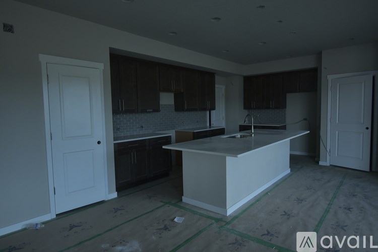 A kitchen under construction with a white island in the middle.