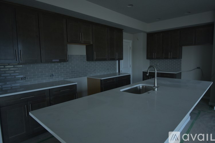A kitchen with dark brown cabinets and a white countertop.