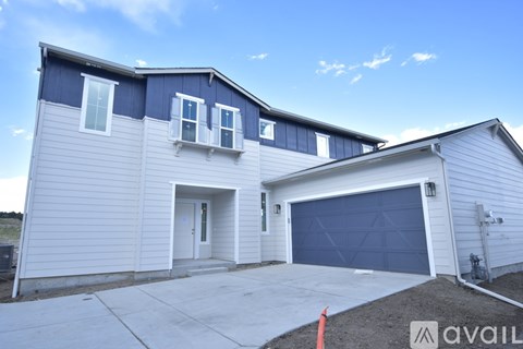 A two-story house with a garage is available for sale.