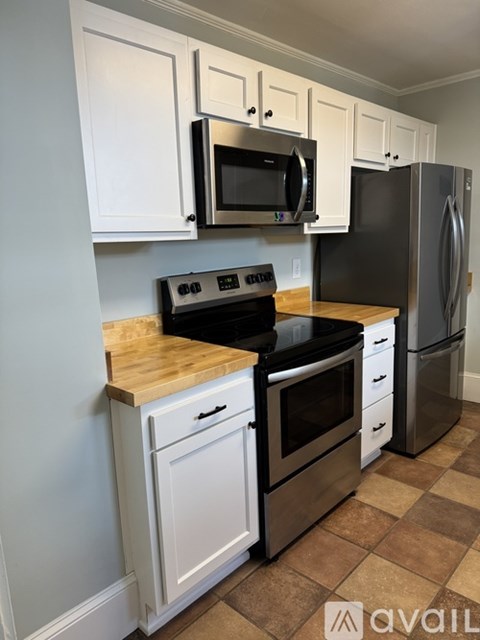 A kitchen with white cabinets and a black stove top oven.