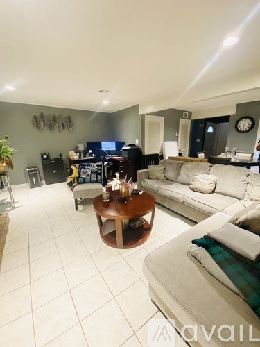 A living room with a white couch and a wooden coffee table.