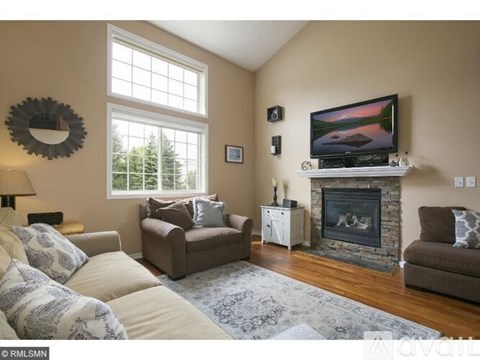 A living room with a fireplace and a television on the wall.