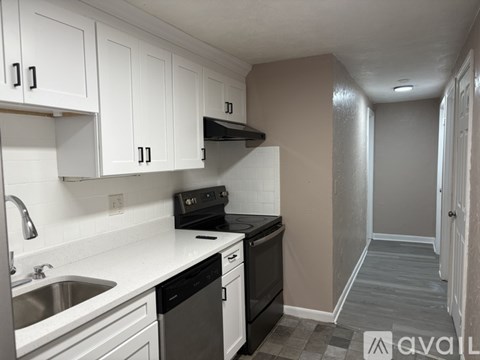 A kitchen with white cabinets and a black stove top oven.