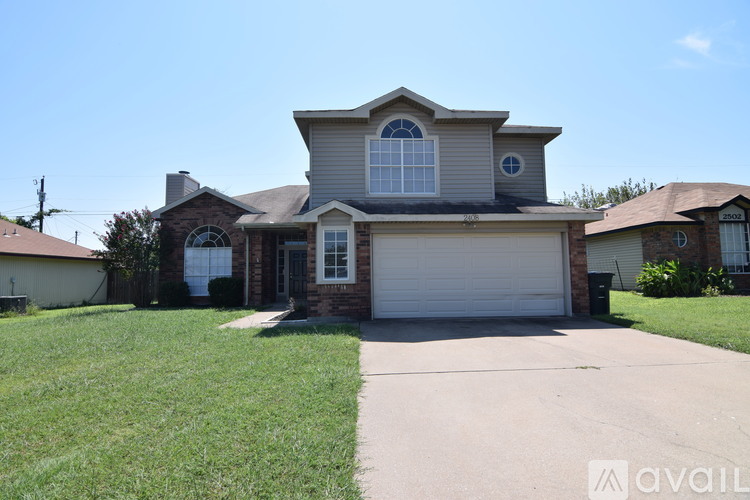 A house with a garage and a driveway in front.