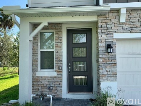 A house with a black front door and a white garage door.