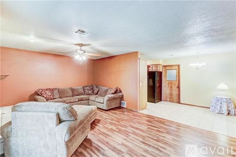 A living room with a grey couch and a wooden floor.