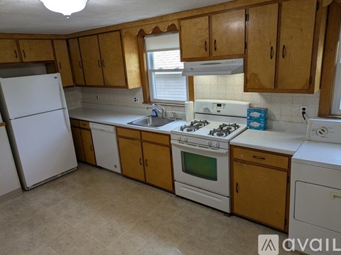 A kitchen with wooden cabinets and white appliances.