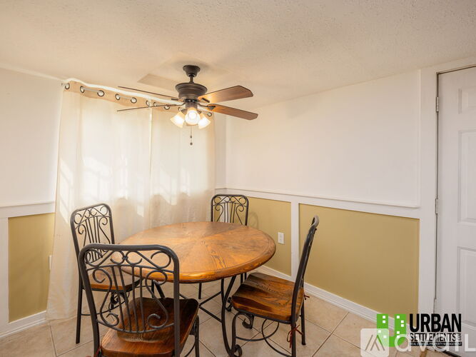 A dining room with a wooden table and chairs.