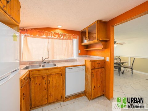 A kitchen with wooden cabinets and a white dishwasher.