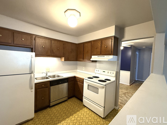 A kitchen with a white refrigerator, white stove, and yellow tiled floor.