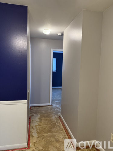 A room with a carpeted floor and a brown door.