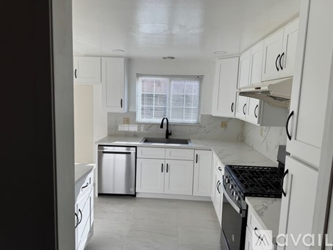A kitchen with white cabinets and appliances.