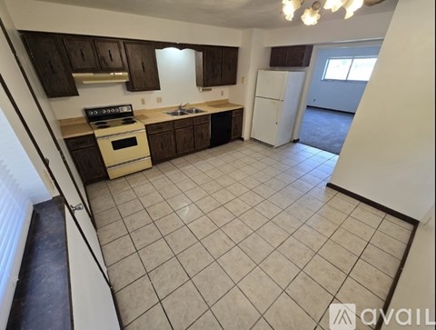 A kitchen with brown cabinets and a white refrigerator.