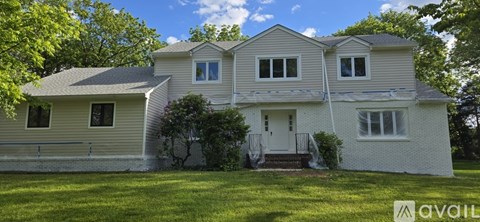 A two-story house with a white exterior and a grey roof.