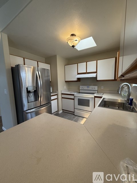 A kitchen with stainless steel appliances and white cabinets.