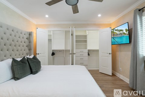 A bedroom with a large bed and a flat screen TV mounted on the wall.
