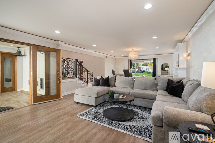 A living room with a grey sofa and a black coffee table.