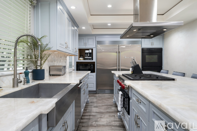 A modern kitchen with stainless steel appliances and marble countertops.