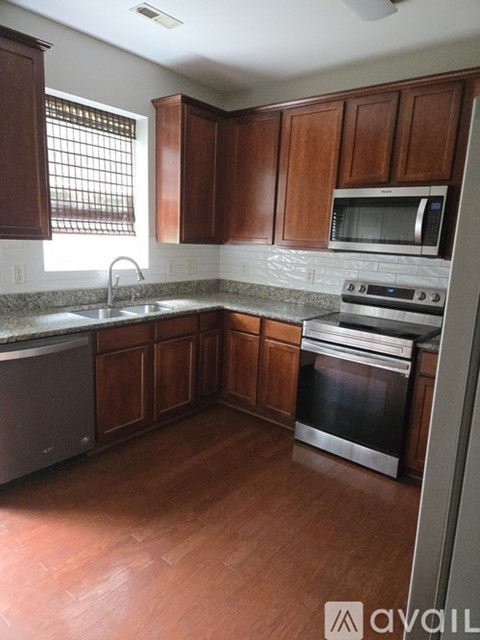 A kitchen with wooden cabinets and stainless steel appliances.