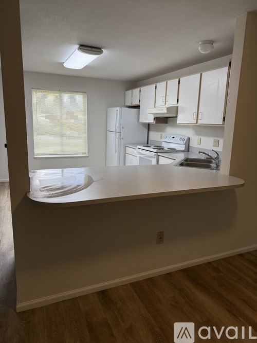 A kitchen with white appliances and cabinets.