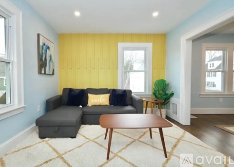 A living room with a grey couch and a wooden coffee table.