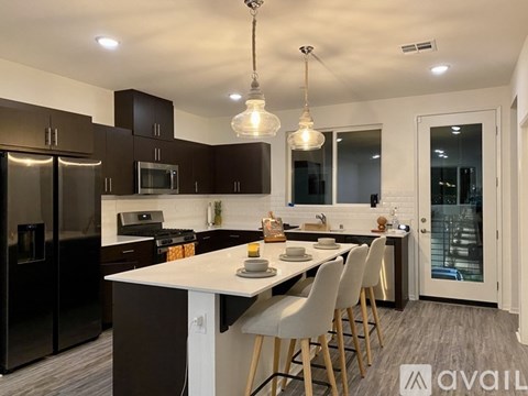 A modern kitchen with dark brown cabinets and a white island.