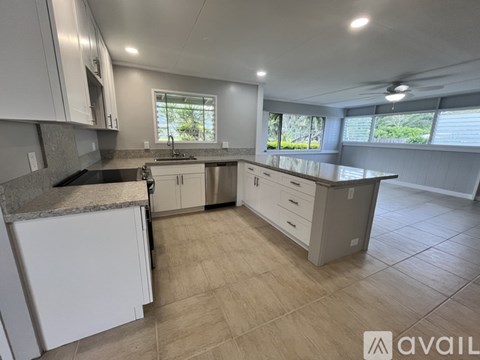 A kitchen with white cabinets and a granite countertop.