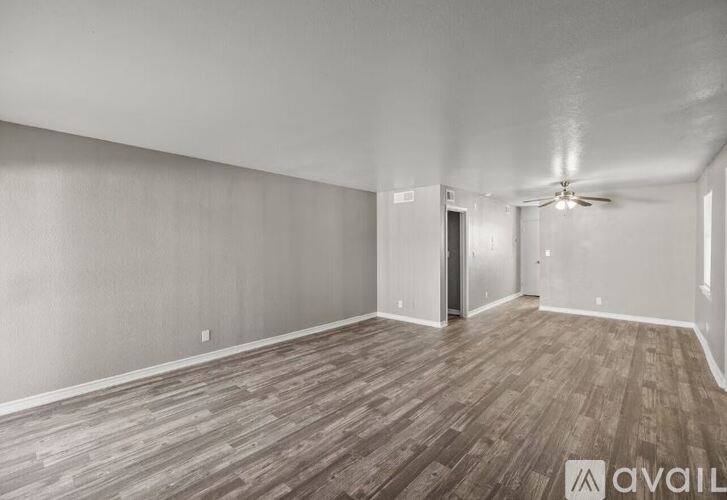 A room with wood flooring and a ceiling fan.