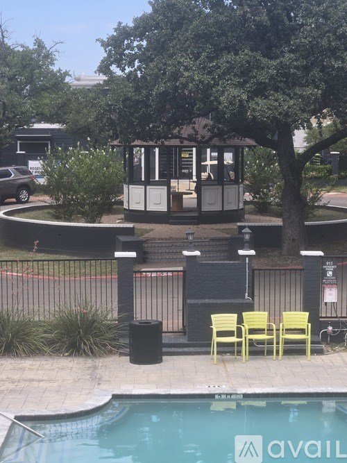 A pool with a lifeguard tower and yellow chairs.