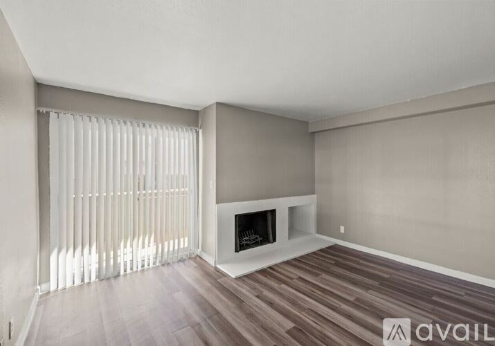 A living room with a fireplace and a window with blinds.