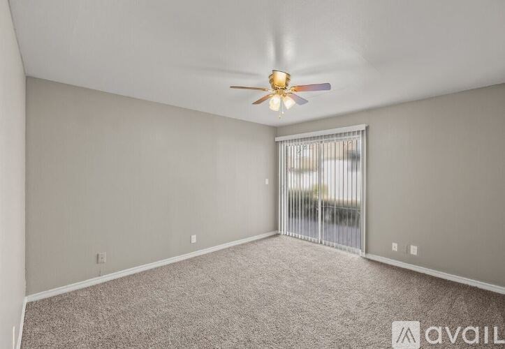 A room with a ceiling fan and carpeted floor.