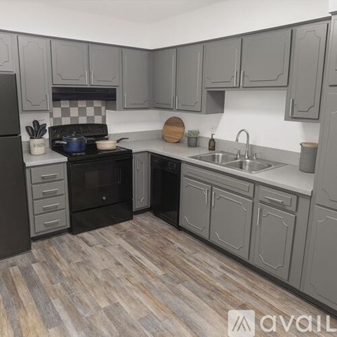 A spacious room with wooden flooring and a large window with blinds.