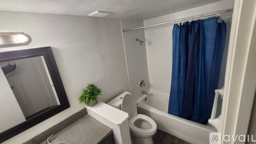 A small bathroom with a toilet, sink, and shower.