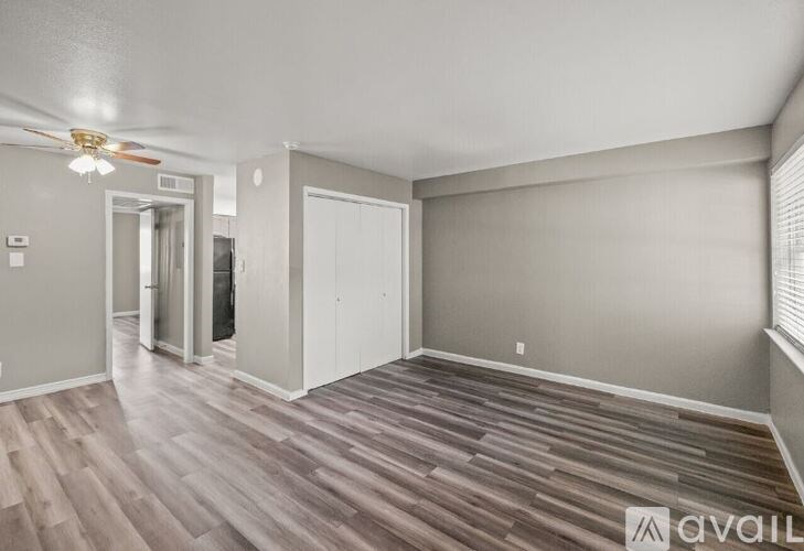 A room with wood flooring and a ceiling fan.